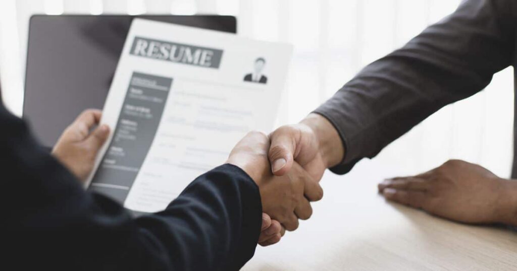 poignée de main entre homme pour engager un employé sur base d'un CV "resume"